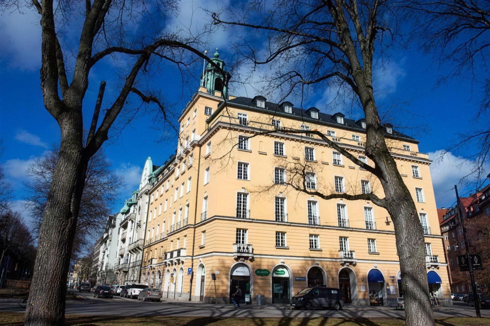 Gult stenhus i stadsmiljö med nymålad fasad