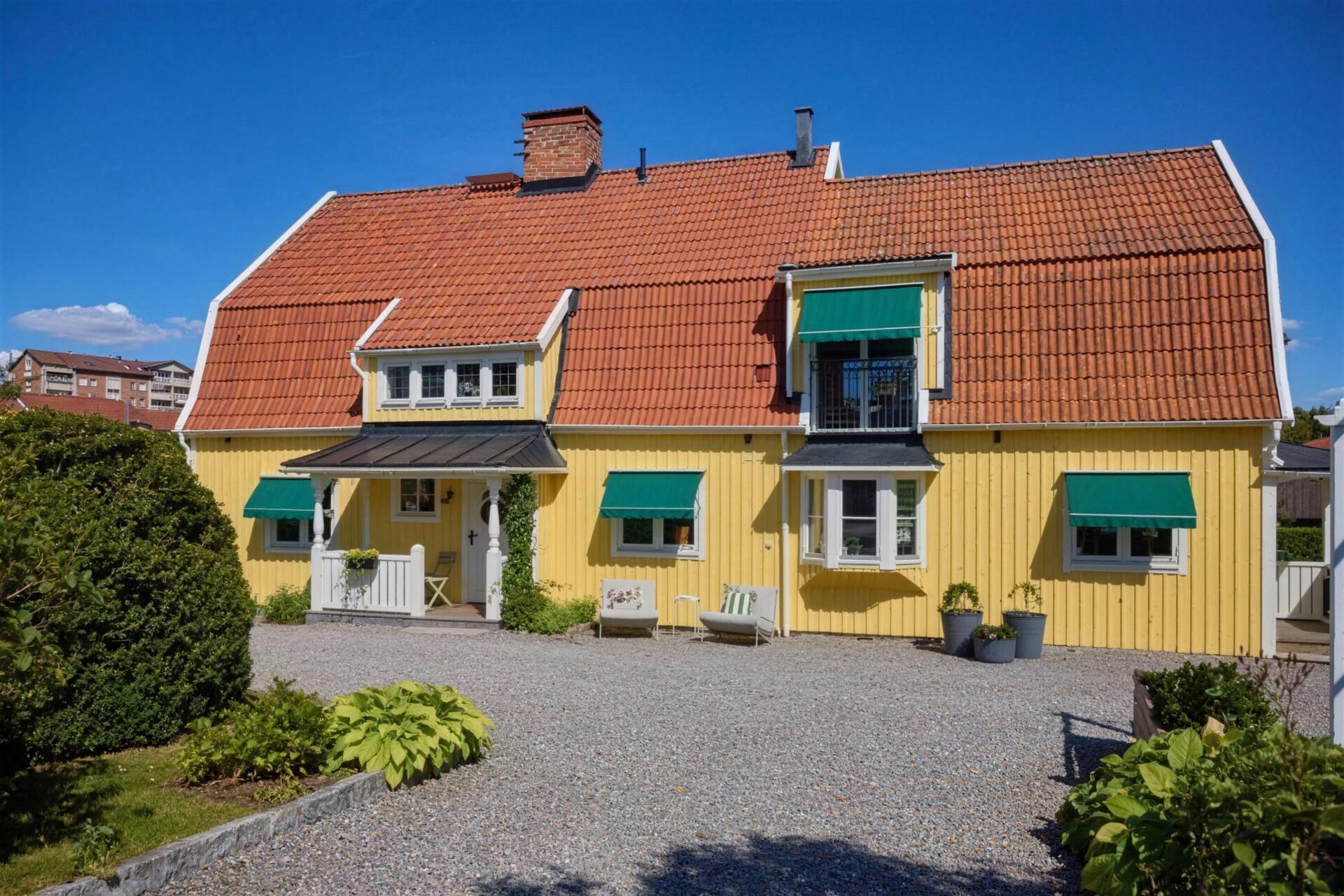 Gul villa med gröna markiser