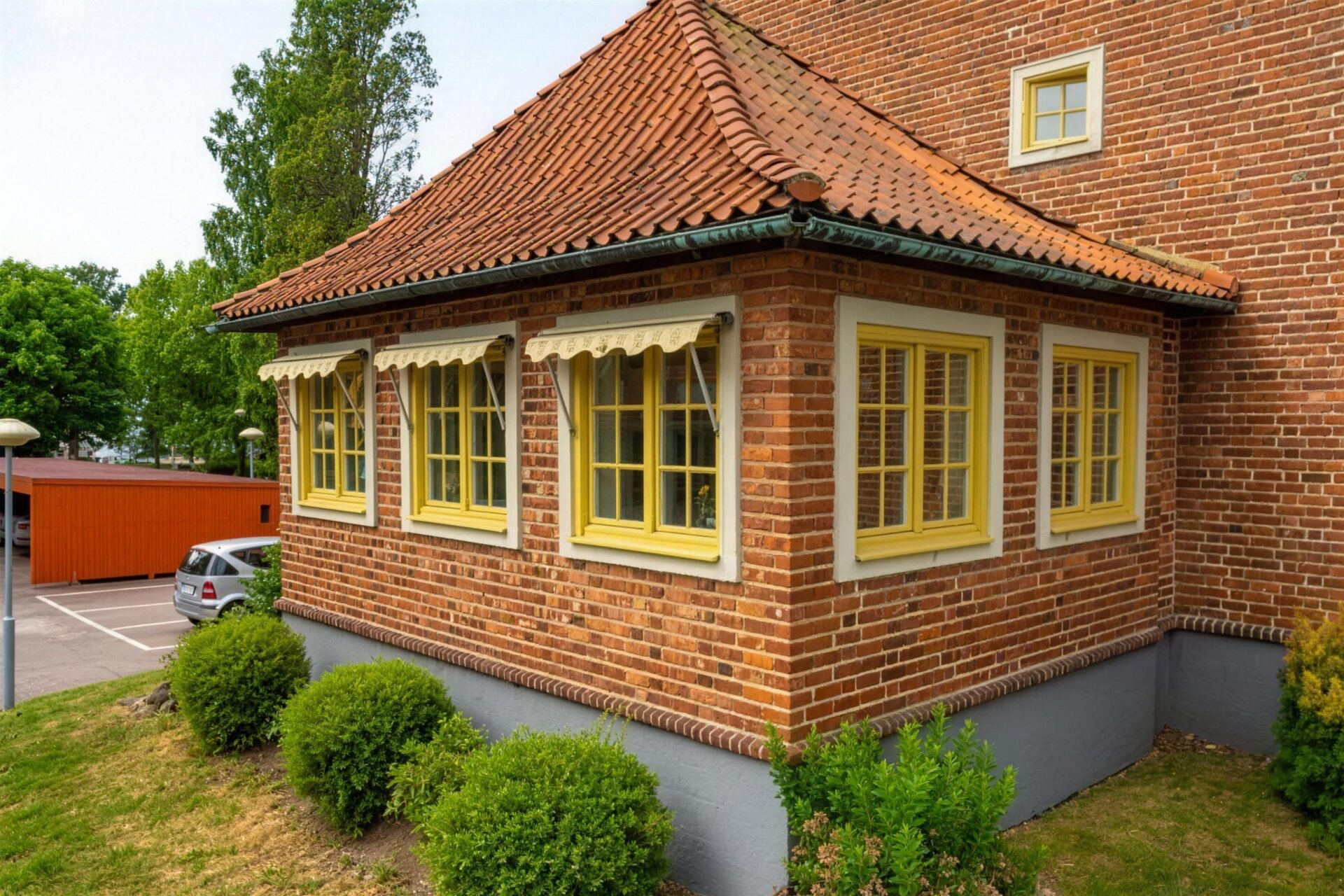 Rött tegelhus med nymålade gula fönster