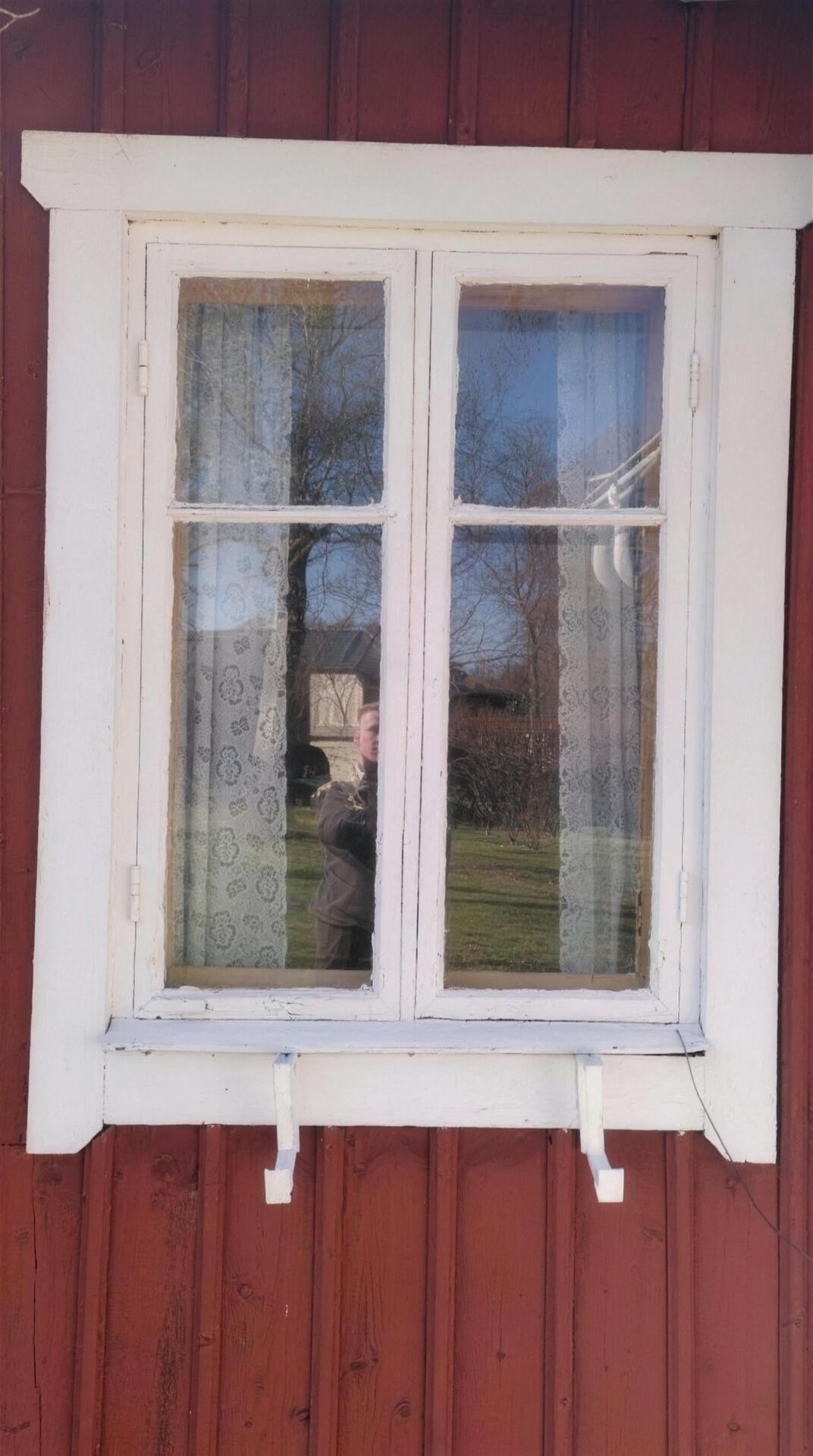 Vitt fönster på röd trävägg